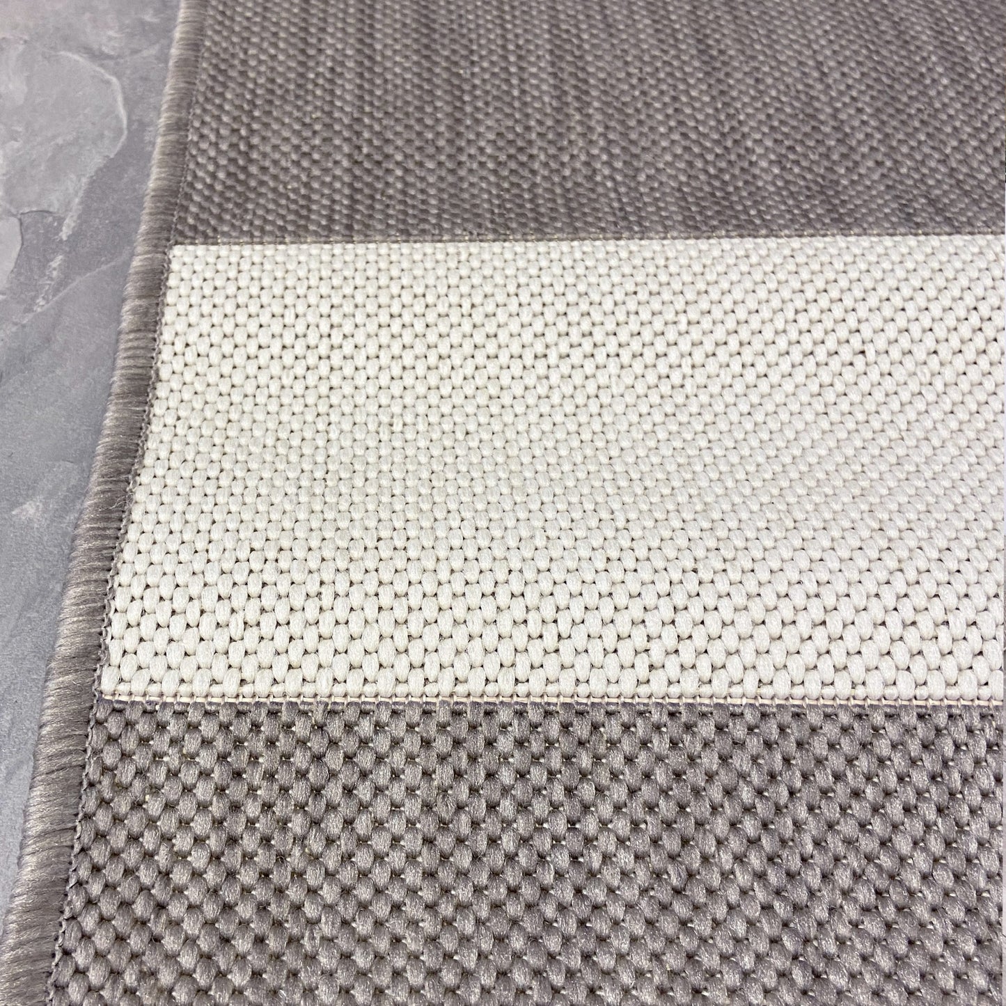The chic and minimal beige and cream stripe outdoor rug with a muted beige chunky line design is an ideal choice for modern outdoor living.